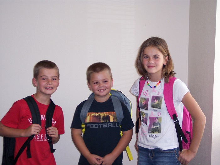 Three children with backpacks on